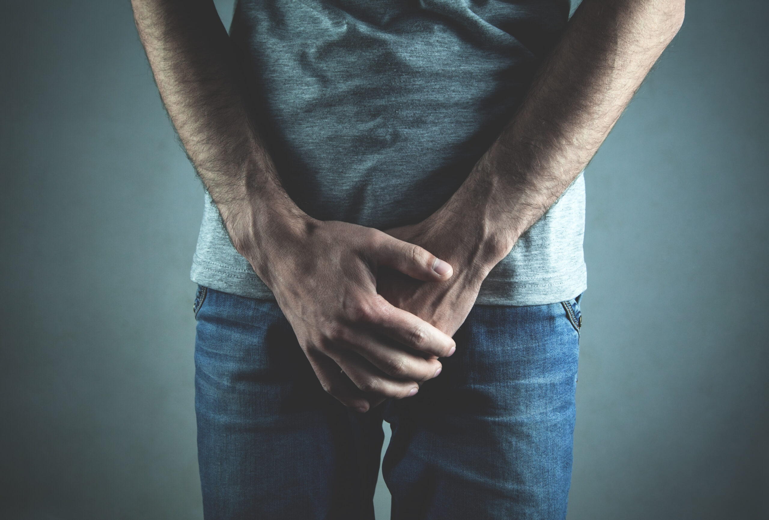 Caucasian man with hands holding his crotch. Inflammation of the